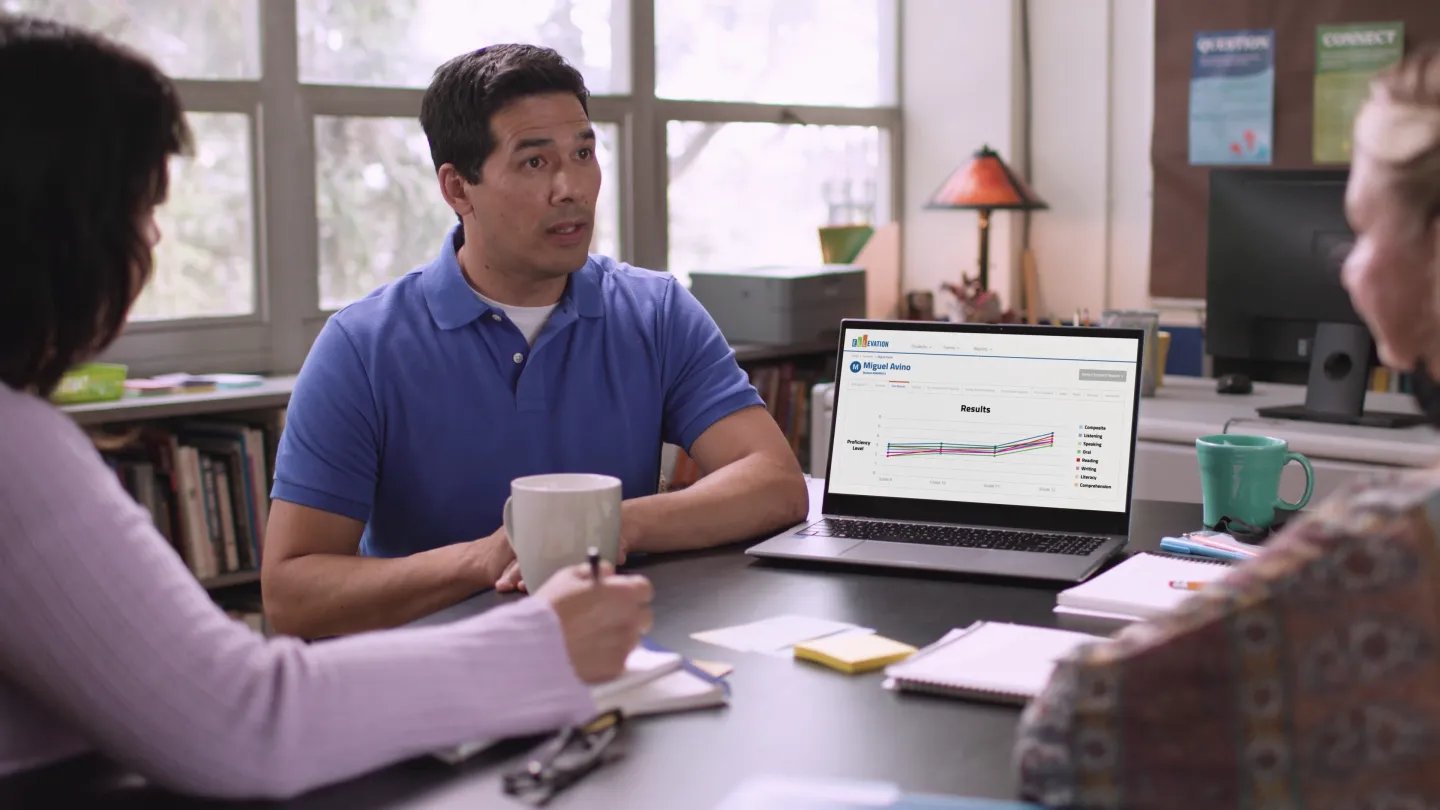 A teacher meets with other teachers as they review a student's progress on Ellevation